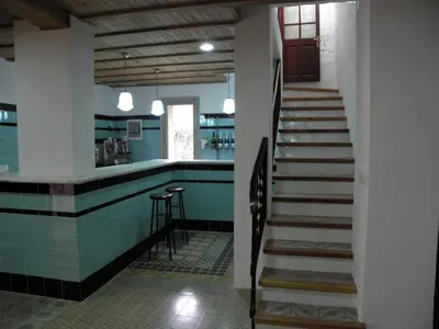 a staircase leading to a kitchen with blue tile at Hostal Cal Pla in Sant Llorenc Savall