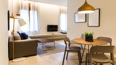 a living room with a table and a couch at Fisa Rentals Ramblas Apartments in Barcelona
