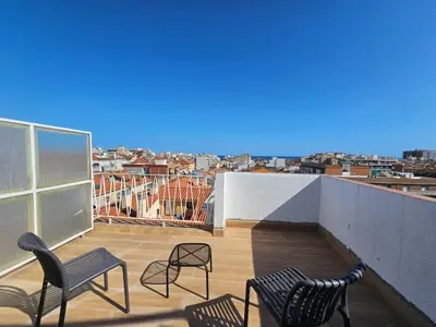 a balcony with chairs and a view of a city at Hotel Mar i Sol in Calella