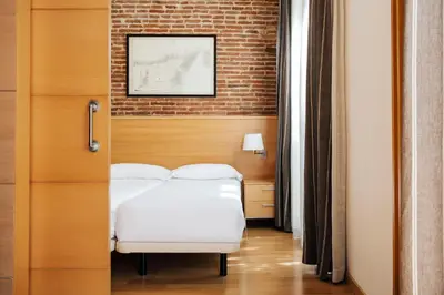 a bedroom with a bed and a brick wall at Wello Apartments in Barcelona