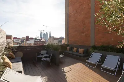 a balcony with chairs and a couch on a building at Aspasios Sagrada Familia Apartments in Barcelona