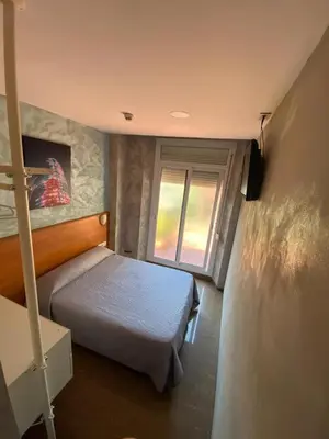 a bedroom with a bed and a window at Hostal Drassanes in Barcelona