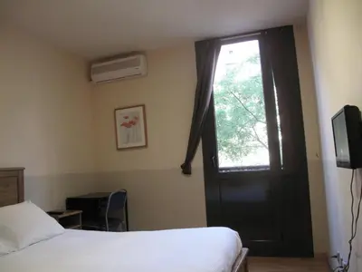a bedroom with a bed and a window and a door at Hostal LK Barcelona in Barcelona