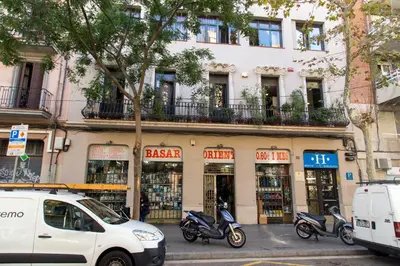 a white van parked in front of a building with scooters at Hostal LK Barcelona in Barcelona