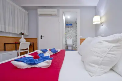 a bedroom with a red and white bed with pillows at Barcelona City Rooms Hostal in Barcelona