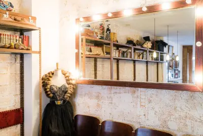 a dress hanging on a wall with a mirror at Pars Teatro Hostel in Barcelona