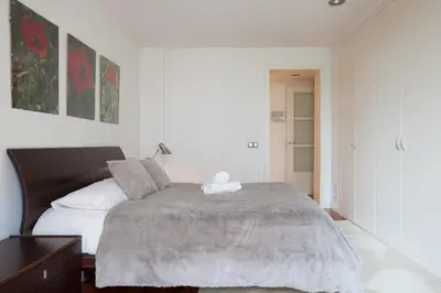 a white bedroom with a bed with a gray blanket at Akira Flats Plaza Catalunya Centric apartments in Barcelona