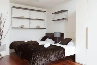 two beds in a room with white walls at Akira Flats Plaza Catalunya Centric apartments in Barcelona