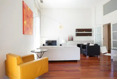 a living room with a yellow chair and a couch at Akira Flats Plaza Catalunya Centric apartments in Barcelona