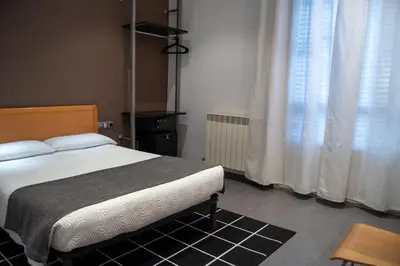 a bedroom with a bed and a window with curtains at Hostal Apolo in Barcelona
