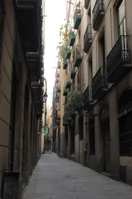 an alley with buildings and a person walking down the street at Hostel New York in Barcelona
