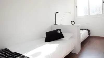 a white room with two beds and a window at AB Montjuic in Barcelona