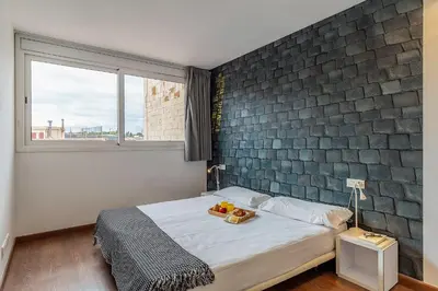 a bedroom with a bed and a brick wall at AB Montjuic in Barcelona
