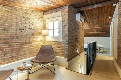 a room with a chair and a brick wall at AB Poble Nou Venero in Barcelona