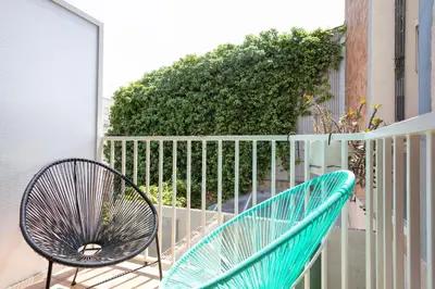 a blue chair sitting on a balcony next to a fence at Casa Barcelo Camp Nou Barcelona in Hospitalet de Llobregat