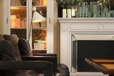 a living room with leather chairs and a fireplace at Ofelias Hotel 4Sup in Barcelona