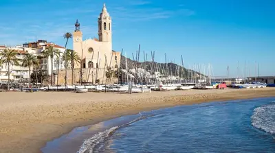 a building with a clock tower and a marina with boats at Villa Bianca in Sitges