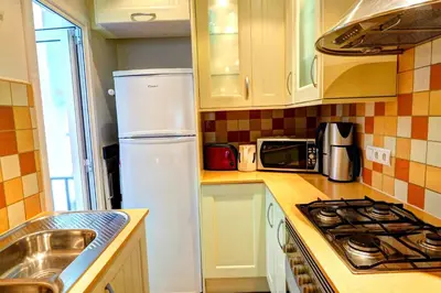 a kitchen with a white refrigerator and a sink at Olivia Apartment by Hello Homes Sitges in Sitges