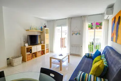 a living room with a blue couch and a table at Lucy Apartment by Hello Homes Sitges in Sitges