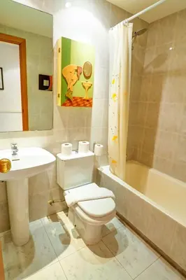 a bathroom with a toilet and a sink and a tub at Lucy Apartment by Hello Homes Sitges in Sitges