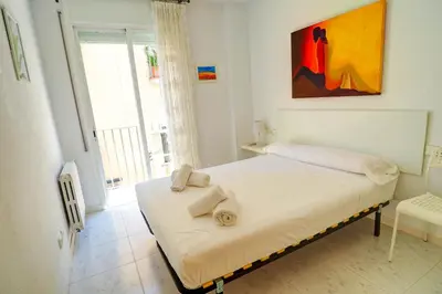 a bedroom with a bed with towels on it at Lucy Apartment by Hello Homes Sitges in Sitges