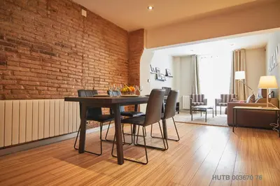 a dining room with a brick wall and a table and chairs at Alcam Alio 1 in Barcelona
