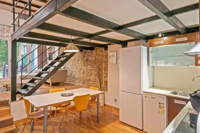 a kitchen and dining room with a table and a refrigerator at Alcam Loft Grassot in Barcelona