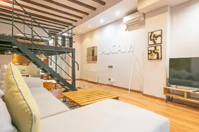 a living room with a couch and a tv at Alcam Loft Grassot in Barcelona