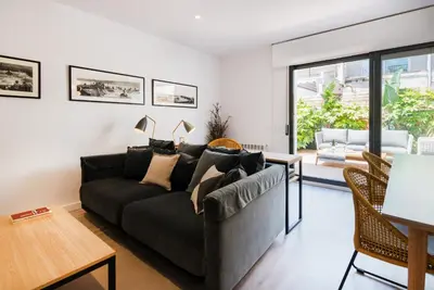 a living room with a black couch and a table at Petit Luxe Dúplex in Terrassa