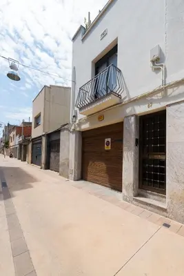 a building with two garage doors on a street at Petit Luxe Dúplex in Terrassa