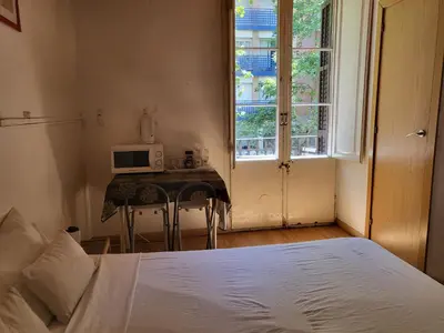 a bedroom with a bed and a table with a microwave at Barcelona Rooms 294 in Barcelona