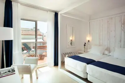a bedroom with a large bed and a balcony at Hotel Medium Sitges Park in Sitges