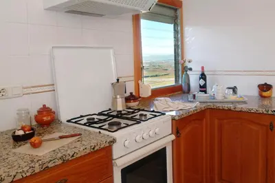 a kitchen with a white stove and a window at Agroturisme Cal Jeroni in Avinyonet