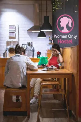 two people sitting at a table in a restaurant at Buba House - Women Only Hostel in Barcelona
