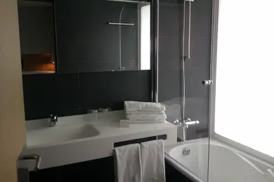 a bathroom with a sink and a shower and a mirror at Atenea Port Barcelona Mataró in Mataró