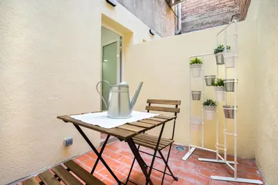 a table on a balcony with a vase on it at Hotelito Boutique Mercat in Hospitalet de Llobregat