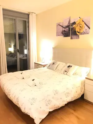 a bedroom with a bed with white sheets and pillows at Duplex in Santa María de Barbará