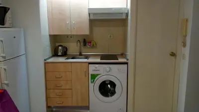 a kitchen with a washing machine and a sink at Estudio con balcon Plaza España in Barcelona