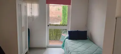 a room with a bed and a door with a window at Estudio con balcon Plaza España in Barcelona