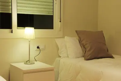 a bedroom with a bed and a lamp on a night stand at Alguera Apartments Industria in Barcelona