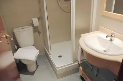 a bathroom with a shower and a toilet and a sink at Alguera Apartments Industria in Barcelona