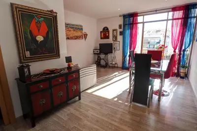 a living room with a table and a painting on the wall at Aquarium Apartment by Hello Homes Sitges in Sitges