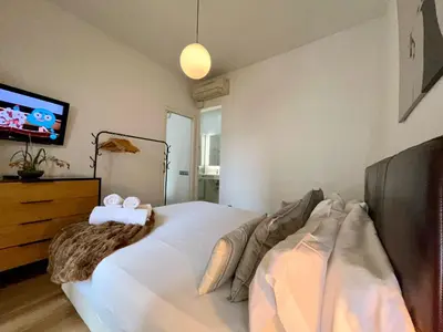 a bedroom with a bed and a tv on the wall at The Gaudi Suites in Barcelona