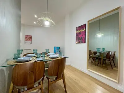 a dining room with a table and chairs in a room at The Gaudi Suites in Barcelona