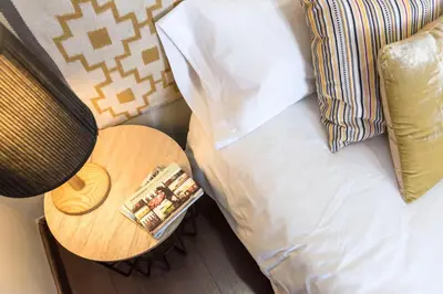 a bed with a table next to a pillow and a side table with a night at The Vintage Rentals in Barcelona