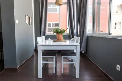 a white table with two chairs and a potted plant on it at The Vintage Rentals in Barcelona