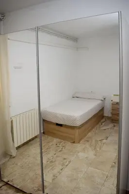 a bedroom with a bed and a glass wall at Apartamentos Atlas Terrassa II in Terrassa