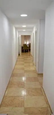 a hallway with a long hallway with a table in a room at Apartamentos Atlas Terrassa II in Terrassa
