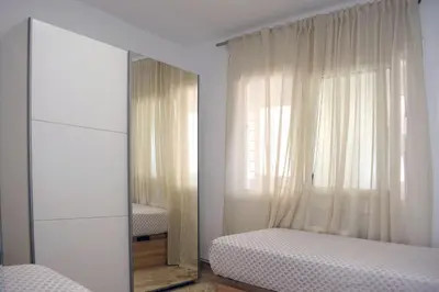 a bedroom with a mirror and a bed and a window at Apartamentos Atlas Terrassa II in Terrassa