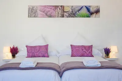 a white bed with purple pillows and towels on it at Charmsuites Paralel in Barcelona
